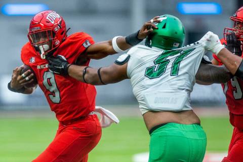 UNLV Rebels running back Aidan Robbins (9) pushes off a tackle attempt by North Texas Mean Gree ...