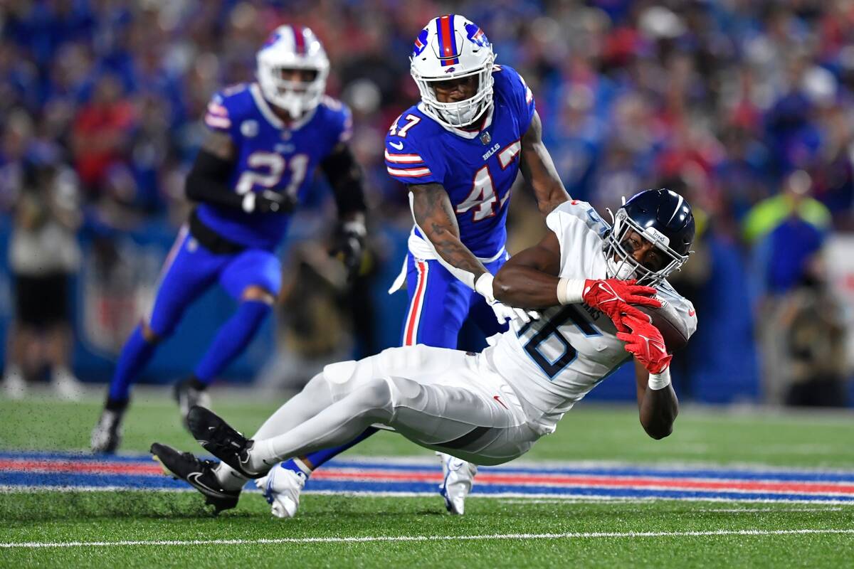 Tennessee Titans' Treylon Burks (16) catches a pass in front of Buffalo Bills' Christian Benfor ...