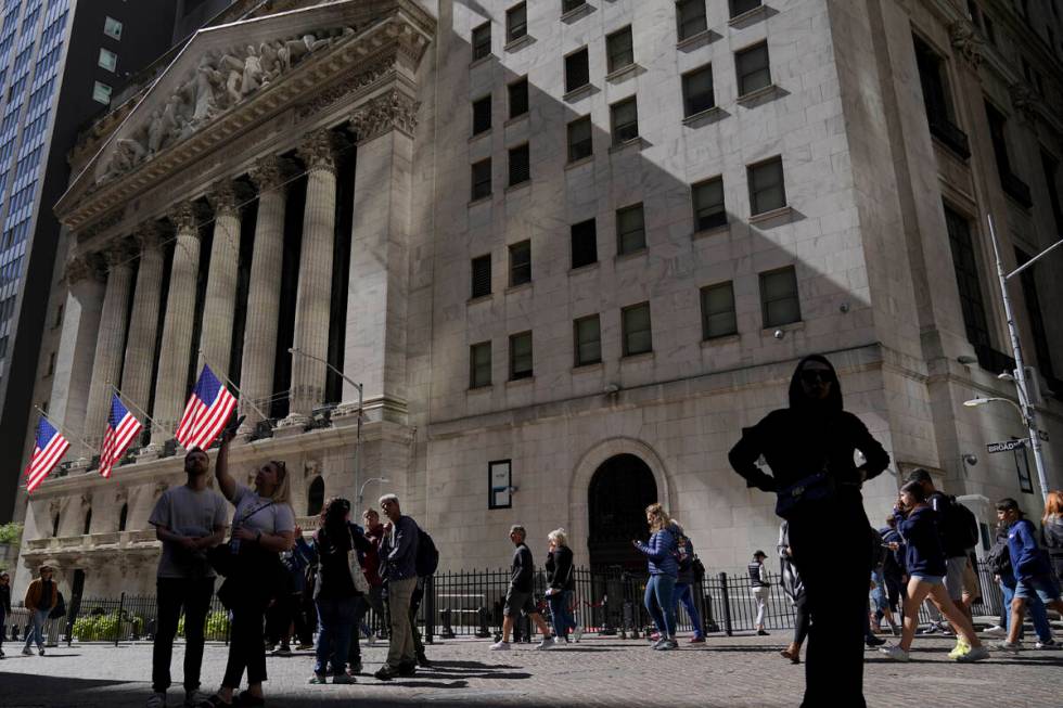 Visitors to the financial district walk past the New York Stock Exchange, Friday, Sept. 23, 202 ...