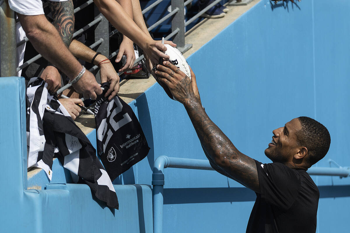 Raiders tight end Darren Waller signs autographs before the start an NFL football game against ...