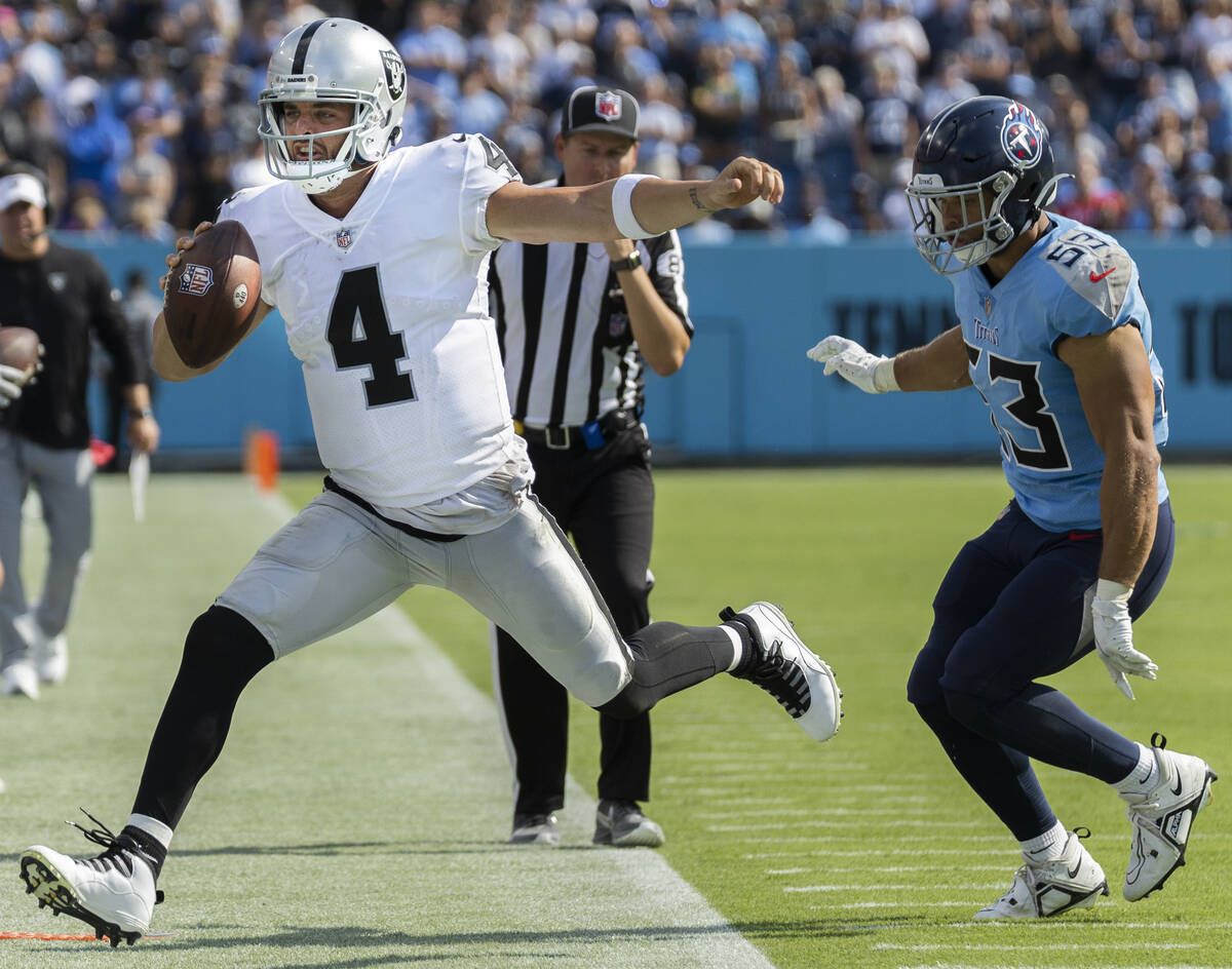 Raiders quarterback Derek Carr (4) tight ropes dow the sideline past Tennessee Titans linebacke ...