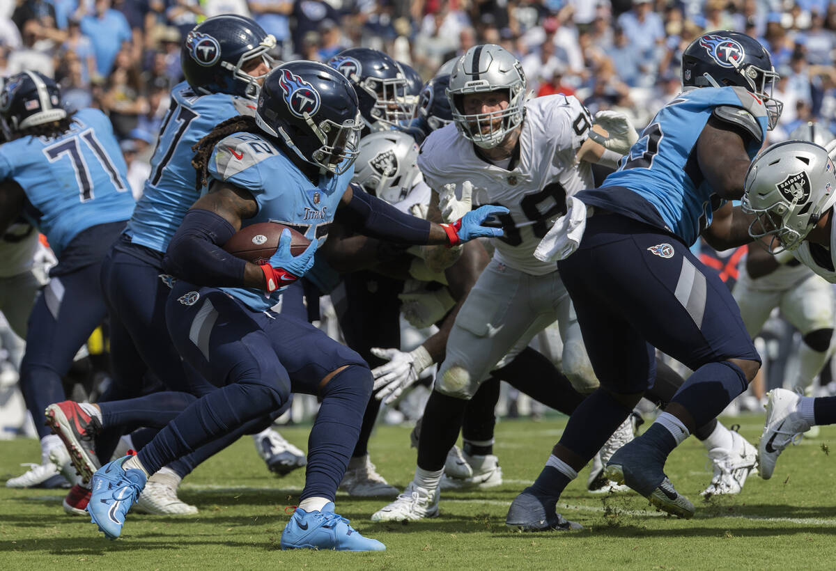 Raiders defensive end Maxx Crosby (98) fights to try and break free to tackle Tennessee Titans ...