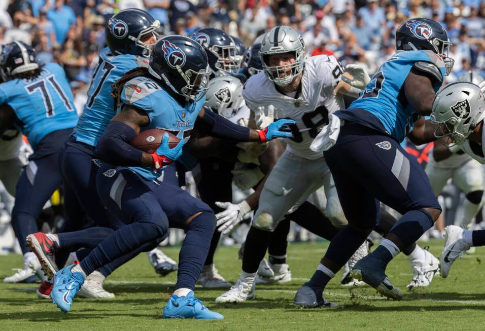 Raiders defensive end Maxx Crosby (98) fights to try and break free to tackle Tennessee Titans ...