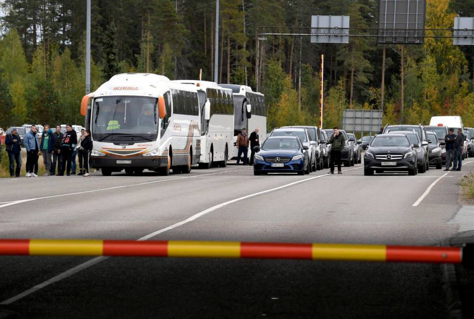 People traveling from Russia in cars and coaches queue to cross the border to Finland at the Va ...