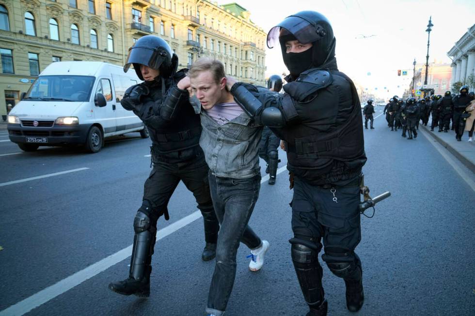 Russian policemen detain a demonstrator protesting against mobilization in St. Petersburg, Russ ...