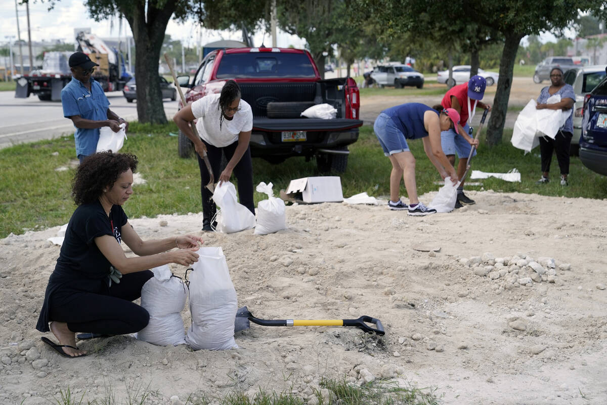 Residents of Orange County fill sand bags at Baldwin Park to protect their homes in preparation ...