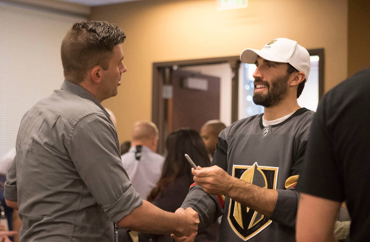 Metro detective Justin Roth, left, shakes hands with Vegas Golden Knights defenseman Jason Garr ...