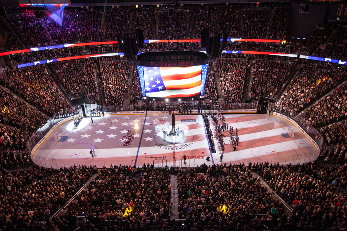 The American flag is displayed on the hockey ring during a ceremony honoring victims and first ...