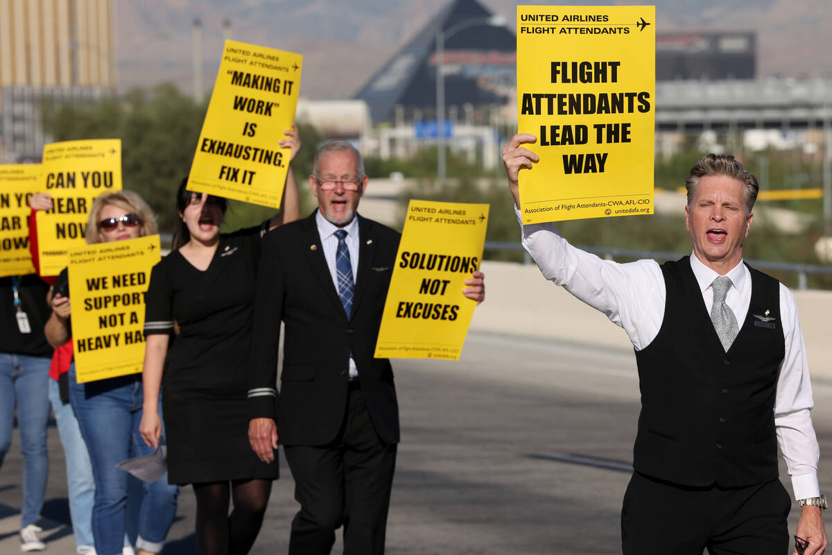 United Airlines flight attendants, including Scott Umfress, right, picket outside Terminal 3 at ...
