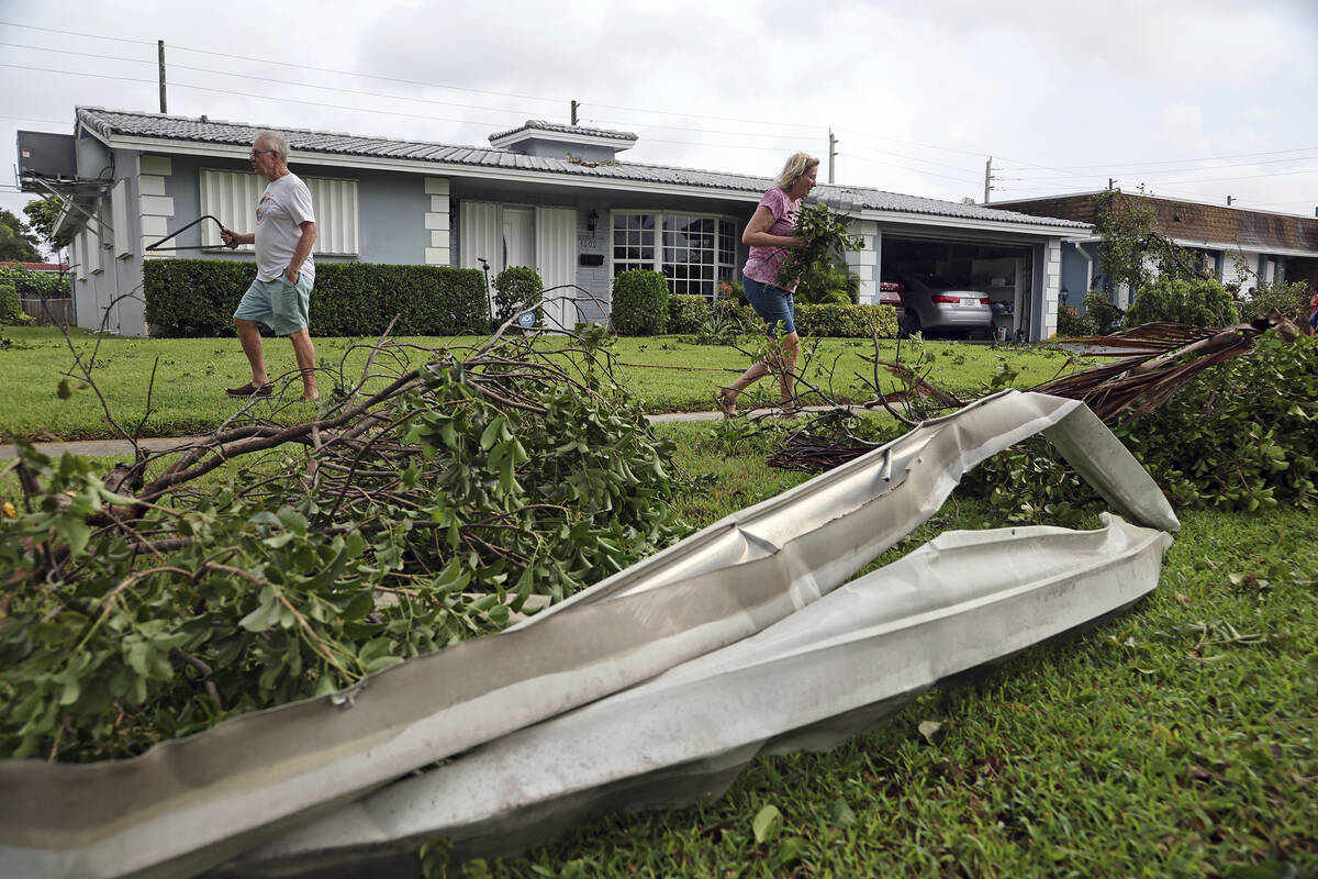 Gary and Sharon Adams clear their yard of debris in Hollywood, Fla., on Wednesday, Sept. 28, 20 ...