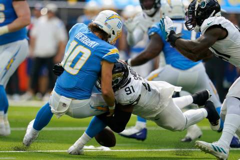 Los Angeles Chargers quarterback Justin Herbert (10) loses a fumble as he is sacked by Jacksonv ...