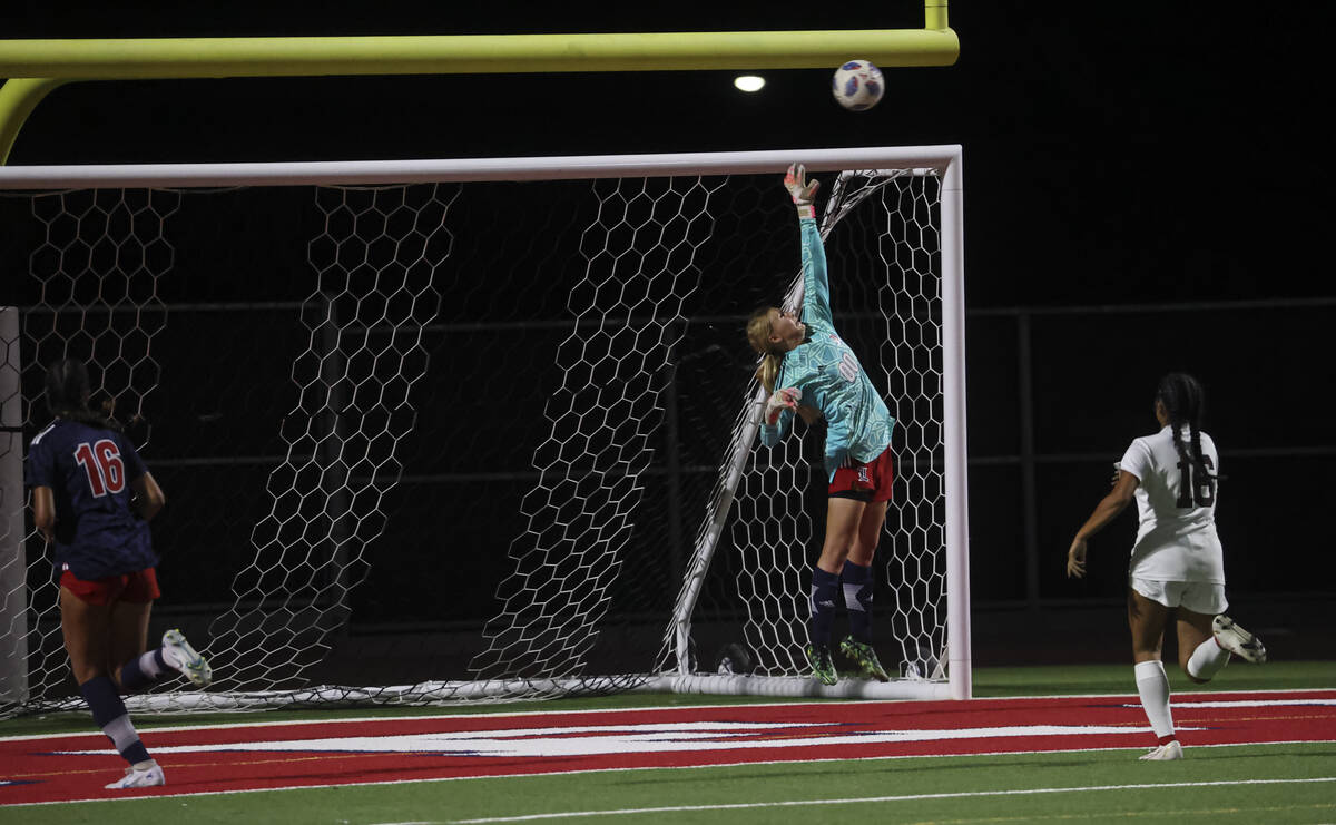 Liberty's Brooke Kramer (00) covers the net as the ball from Desert Oasis narrowly misses durin ...