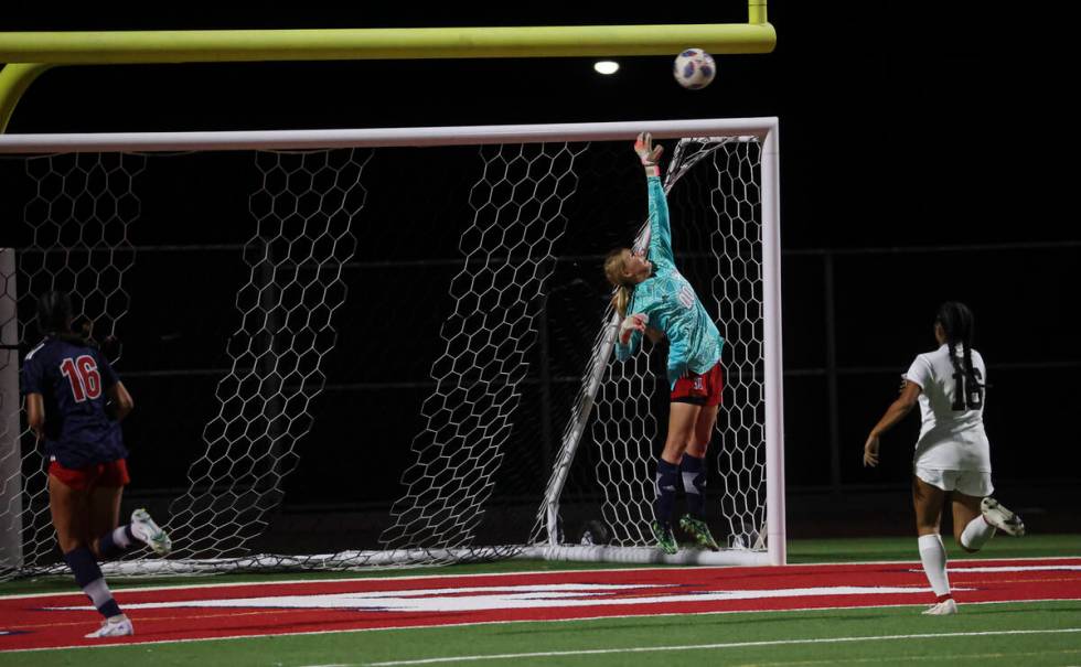 Liberty's Brooke Kramer (00) covers the net as the ball from Desert Oasis narrowly misses durin ...