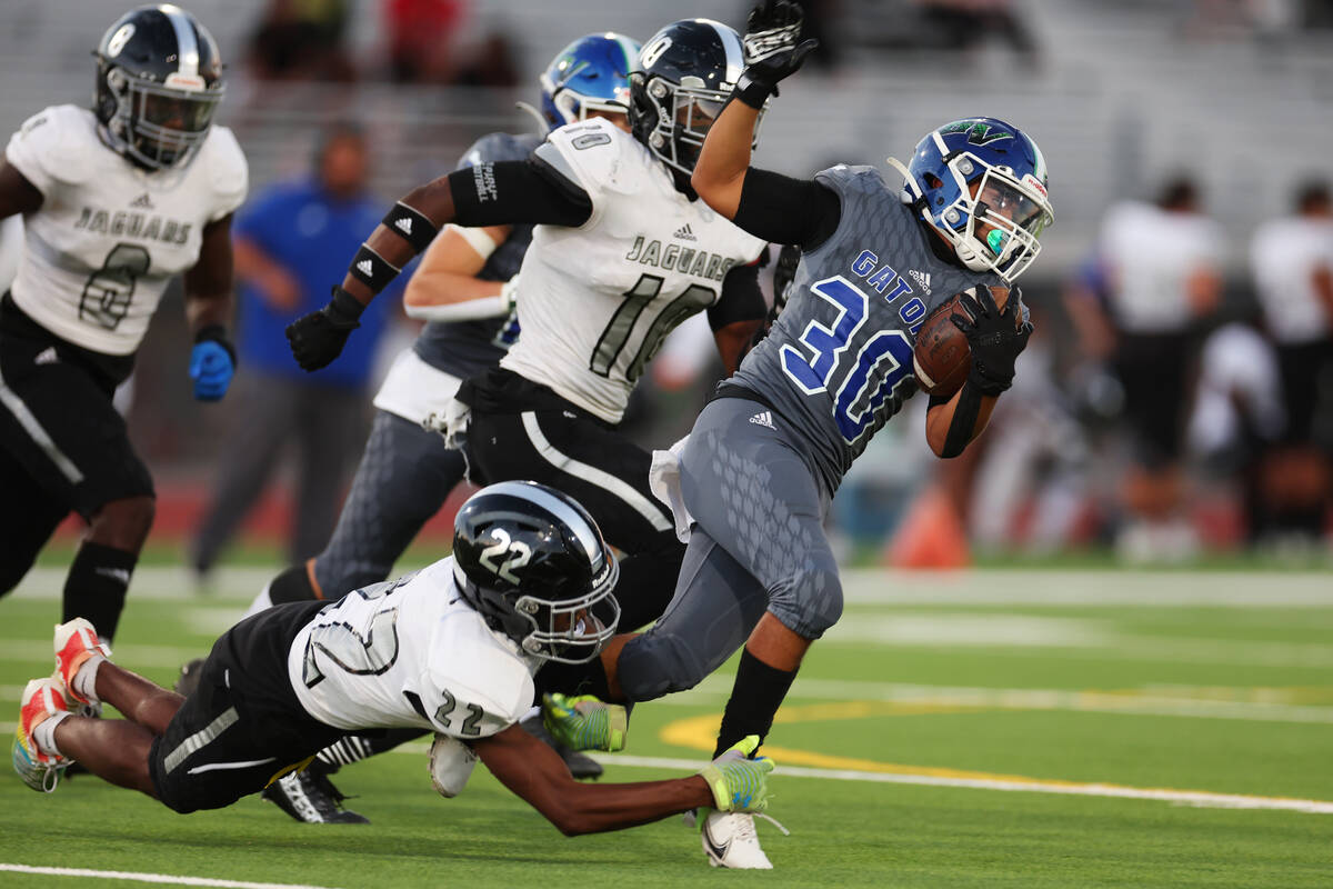 Desert Pines' Trey Jackson (22) tackles Green Valley's Cris Dalina (30) in the first half of a ...