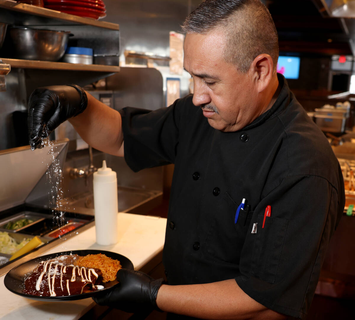Chef Marco Molina makes adobo beef enchiladas at El Luchador Mexican Kitchen & Cantina in Hende ...