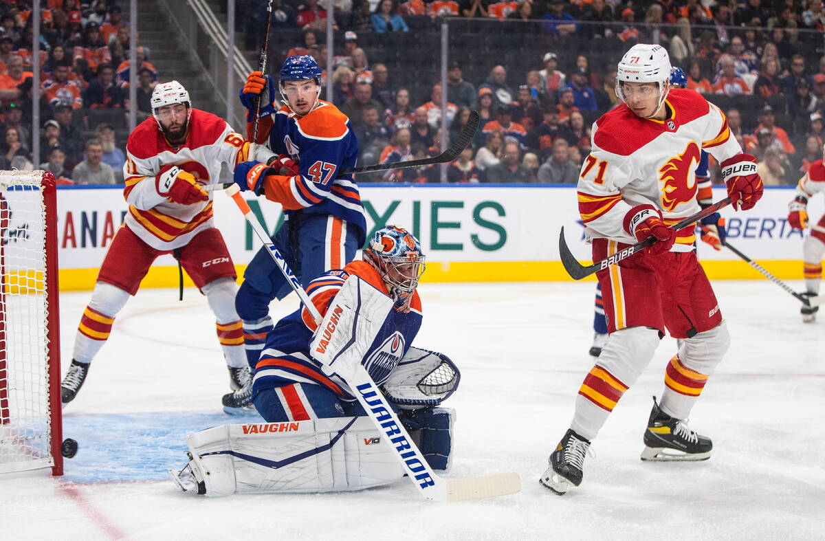 Calgary Flames' Walker Duehr (71) screens Edmonton Oilers goalie Jack Campbell (36), who makes ...
