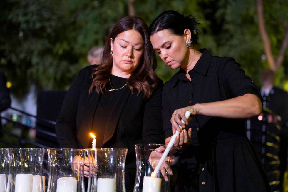 City of Las Vegas employees Maria Bigas, left, and Jasmine Freeman, left, light up a candle for ...