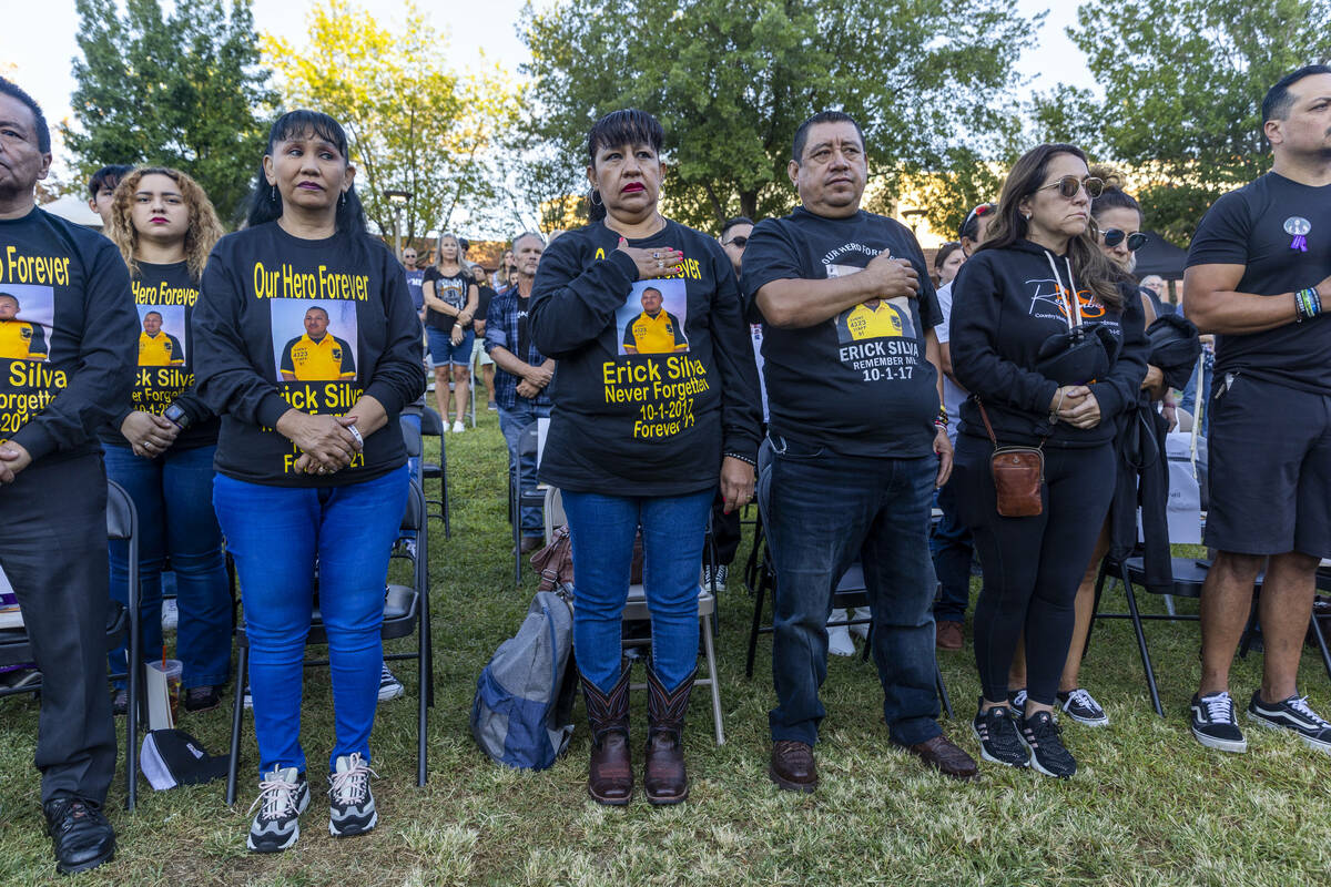 Family and friends of Erick Silva stand for the National Anthem during the Sunrise Remembrance ...