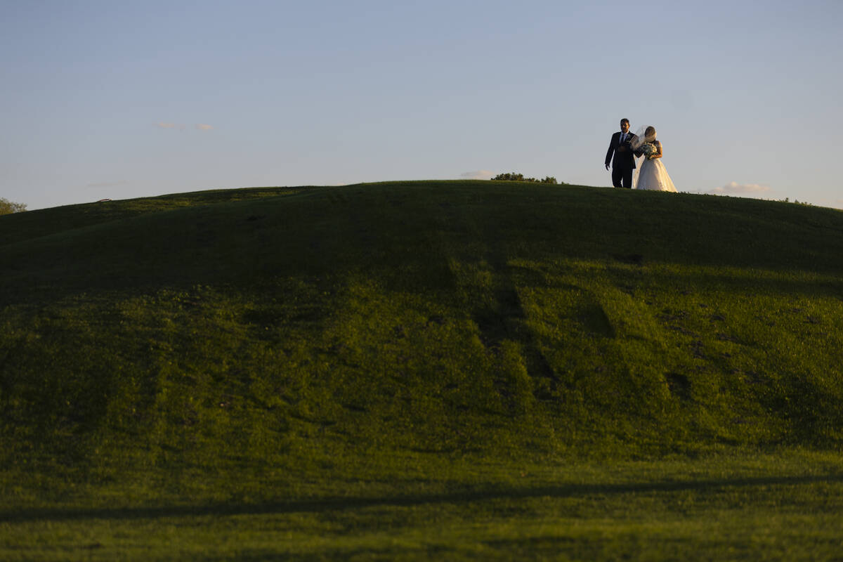 Brittany Castrejon, right, makes her entrance to her wedding ceremony at the Revere Golf Club i ...