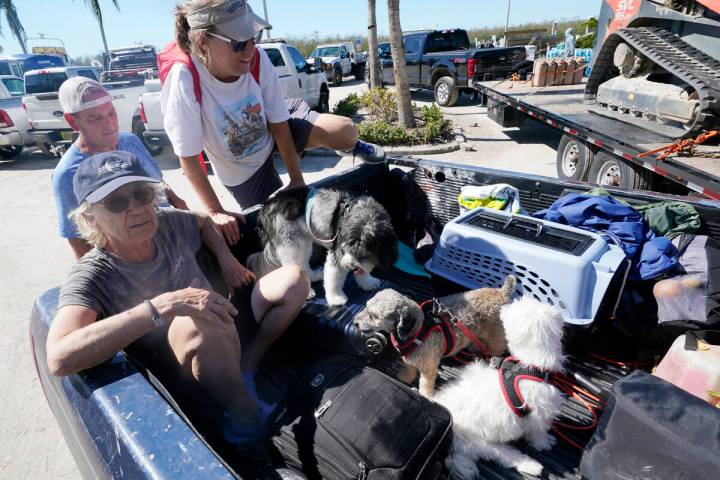 Steve Gibson, left background, helps Maria Zoltac into the back of his truck as her sister Susa ...