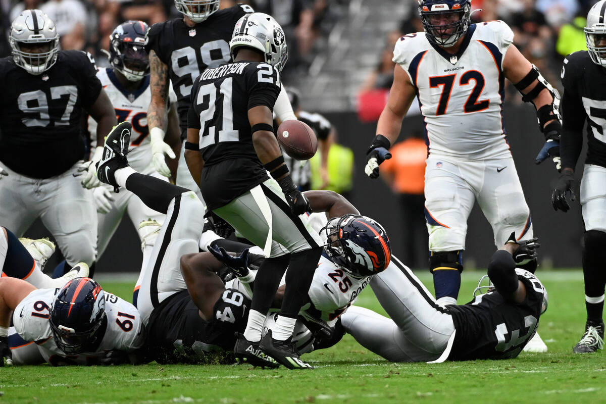 Denver Broncos running back Melvin Gordon III (25) fumbles the football as Las Vegas Raiders co ...