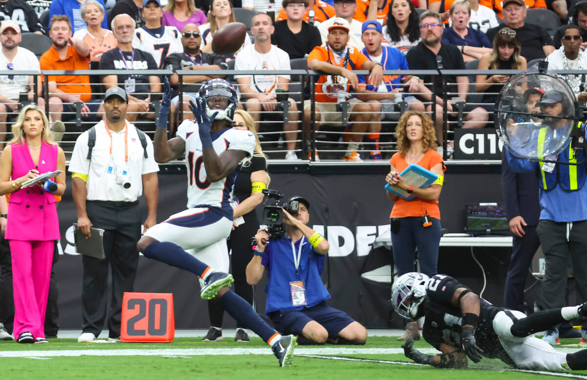 Raiders cornerback Amik Robertson (21) gets tripped up as Denver Broncos wide receiver Jerry Je ...