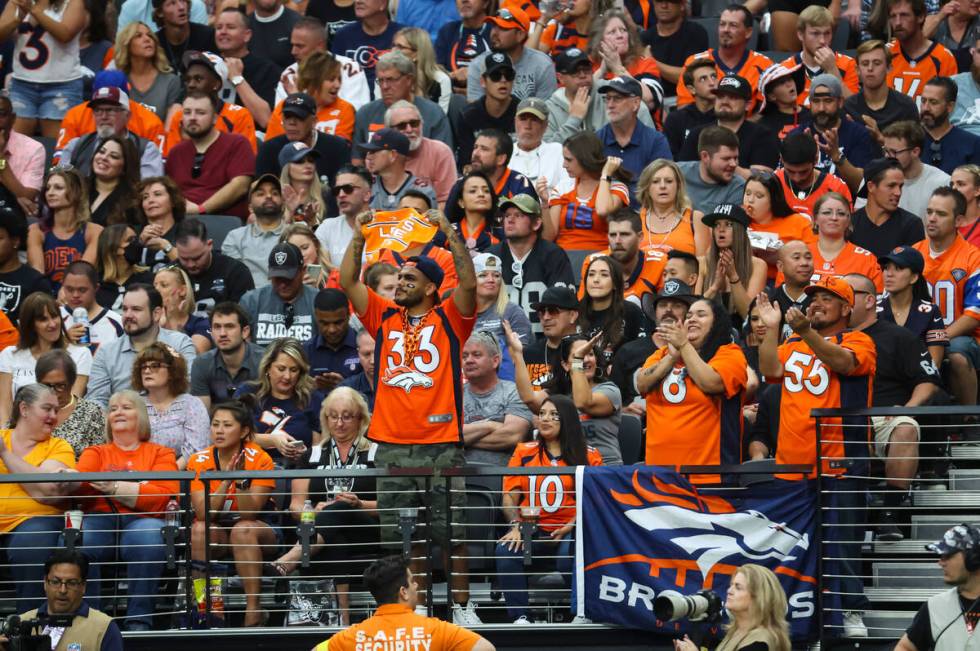 Denver Broncos fans cheer as their team plays the Raiders during the first half of an NFL game ...