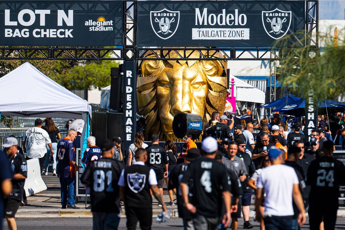 Football fans come and go from the Modelo tailgate zone before the start of an NFL game between ...
