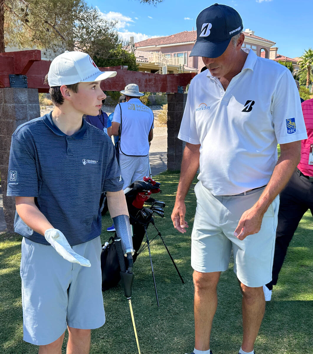 Shriners patient ambassador Isaac Berger, 17, of Neillsville, Wis. shows PGA Tour player Matt K ...