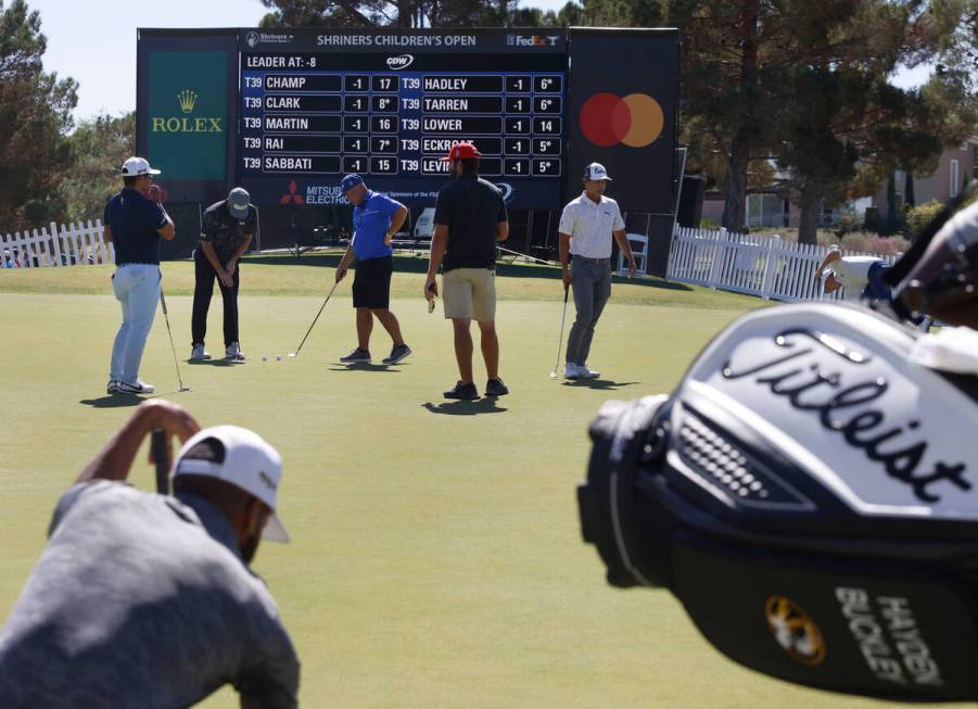 Golfers practice their putts during the first round of the Shriners Children's Open tournament ...