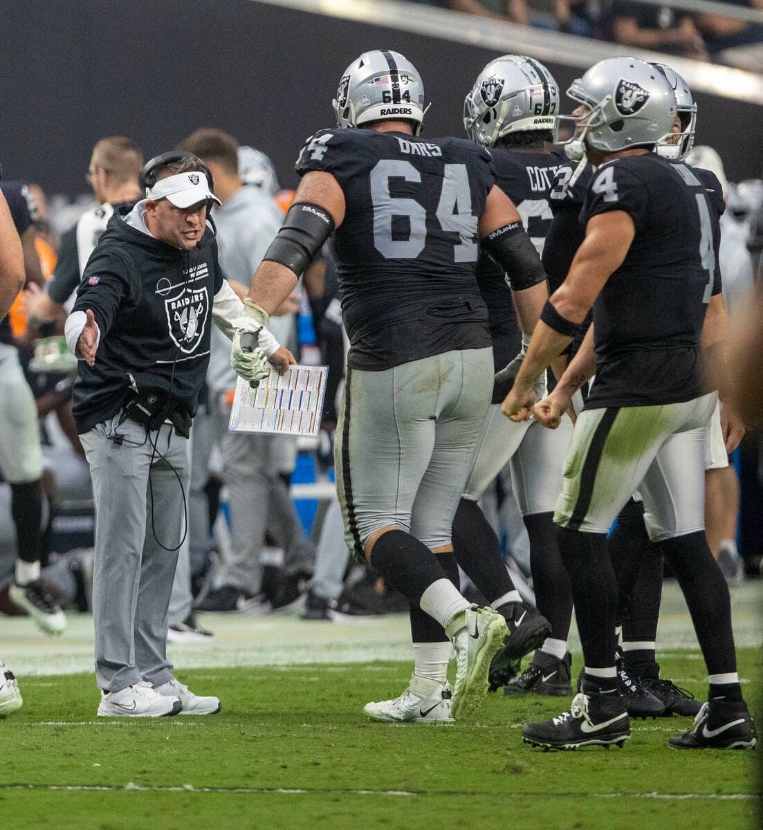 Raiders head coach Josh McDaniels looks to high five Raiders guard Alex Bars (64) after the kic ...
