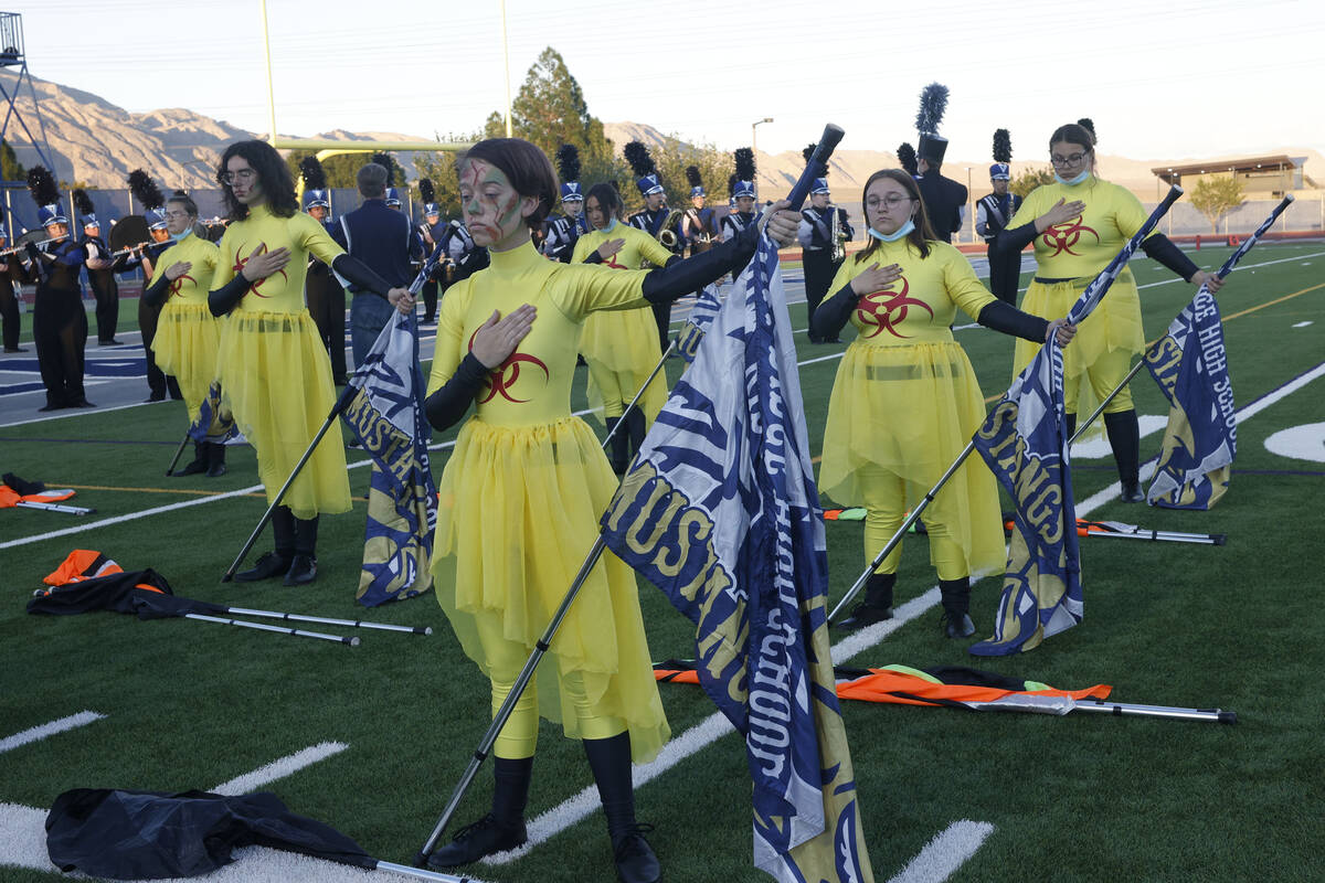 Shadow Ridge High School marching band color guard members are seen during the national anthem ...