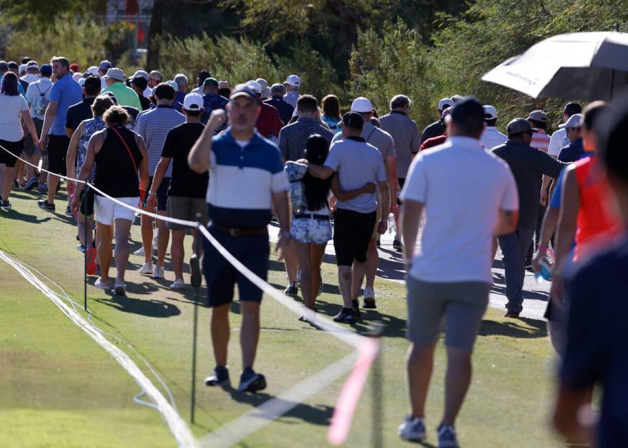 Fans follow golfers during the third round of the Shriners Children's Open tournament at TPC at ...