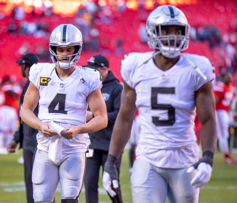 Raiders quarterback Derek Carr (4) and teammate Raiders linebacker Divine Deablo (5) walk off t ...