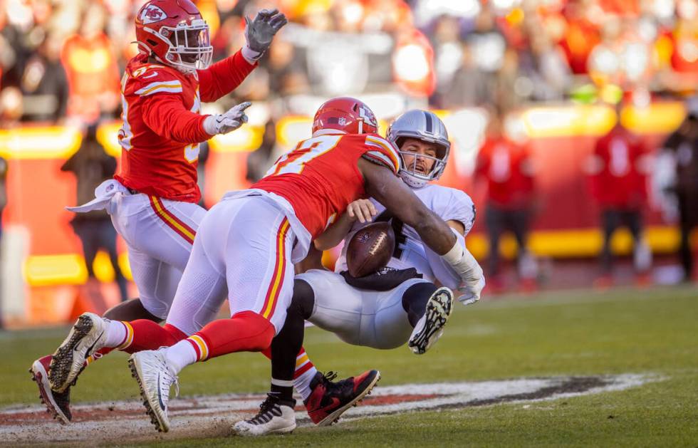 Raiders quarterback Derek Carr (4) is sacked and fumbles the ball after a big hit by Kansas Cit ...