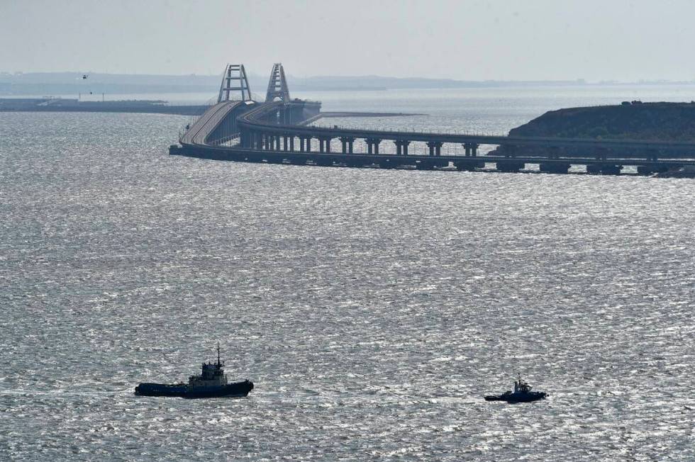 A helicopter flies to drop water to stop fire on Crimean Bridge connecting Russian mainland and ...