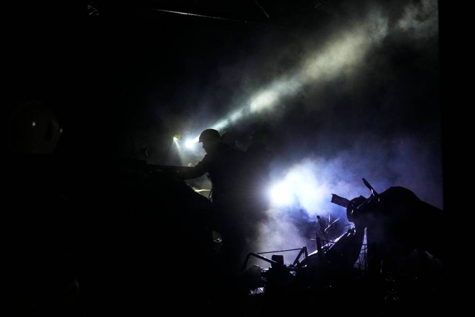 Ukrainian firefighters work among debris following a Russian shelling in Kharkiv, Ukraine, earl ...