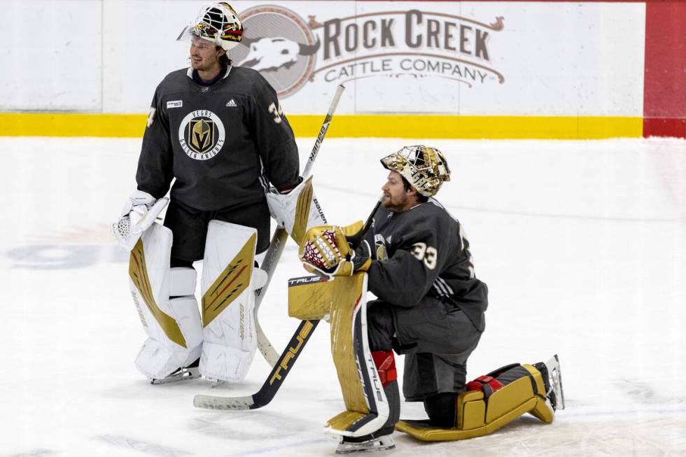 Golden Knights goaltender Michael Hutchinson (34) and goaltender Adin Hill (33) communicate on ...