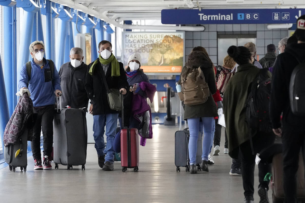 FILE - Travelers walk through Terminal 1 at O'Hare International Airport in Chicago, on Dec. 30 ...