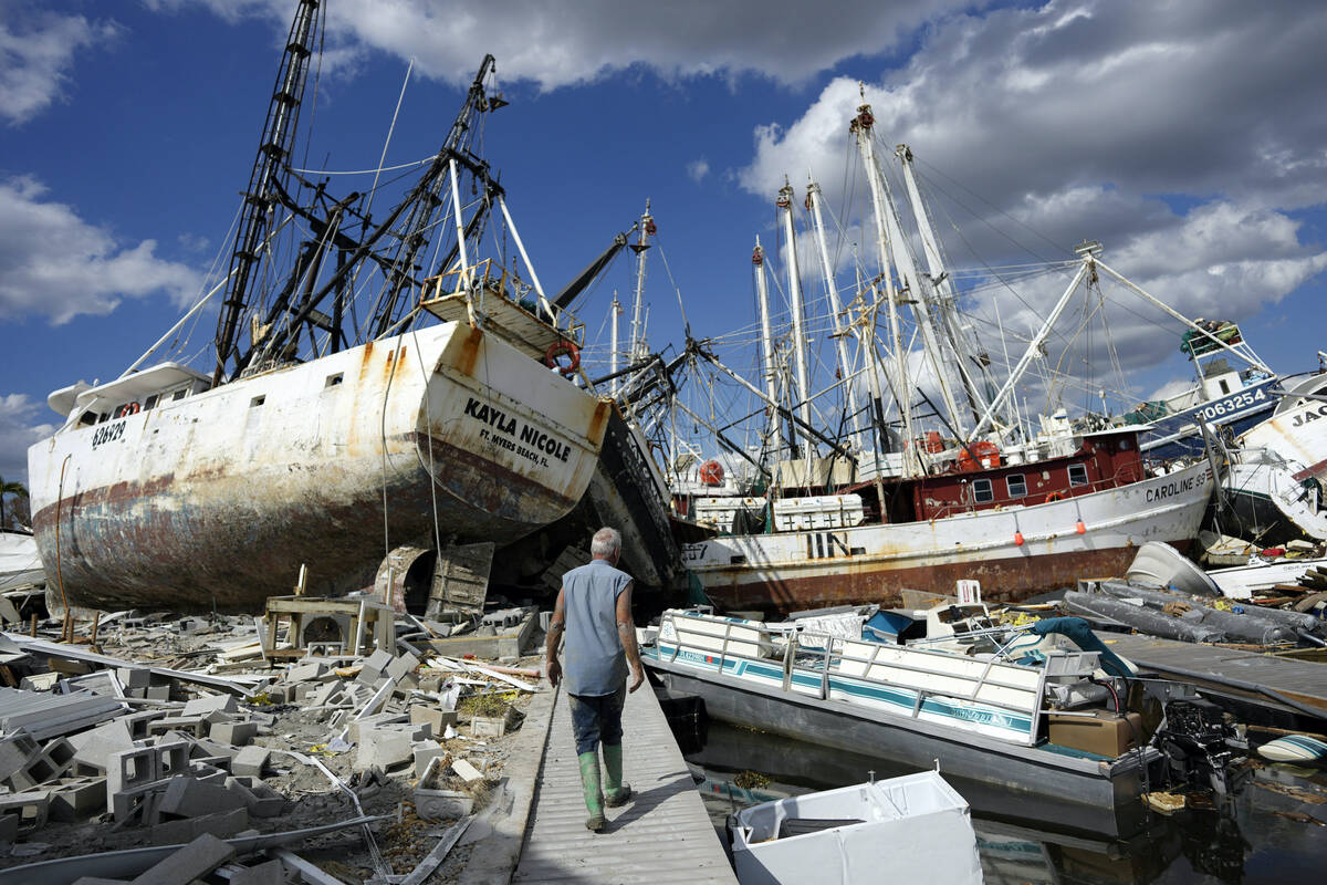 Bruce Hickey, 70, walks along the waterfront littered with debris, including shrimp boats, in t ...