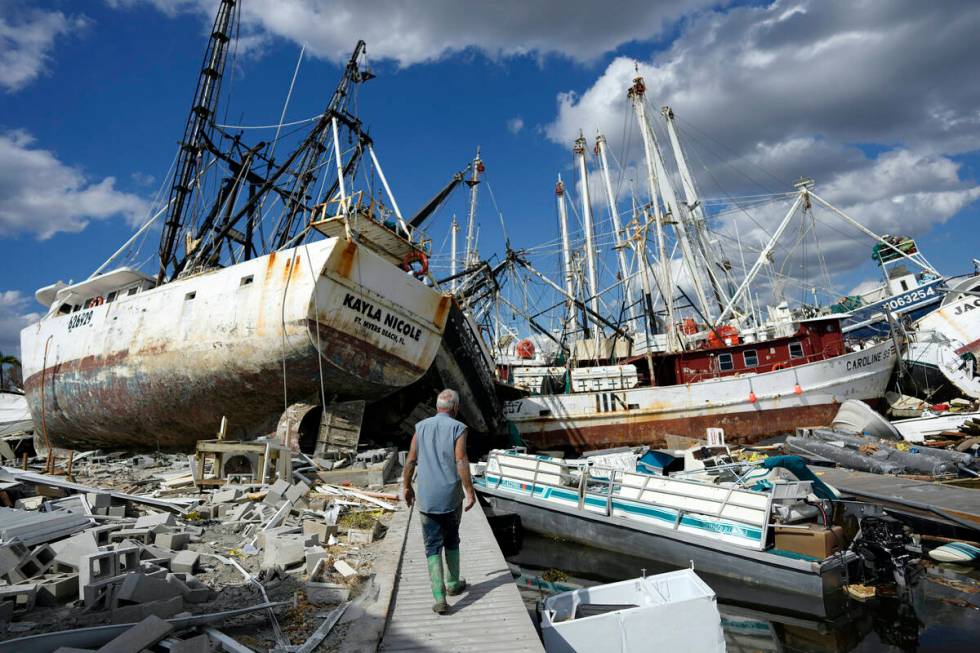 Bruce Hickey, 70, walks along the waterfront littered with debris, including shrimp boats, in t ...