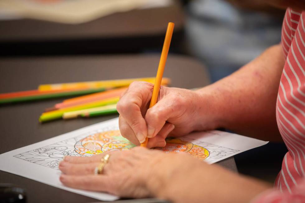 Malinda Henry, 70, colors a halloween themed page during an Adult Coloring and Journaling sessi ...