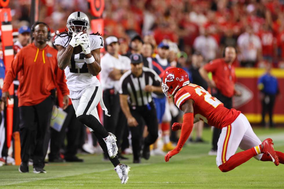 Raiders wide receiver Davante Adams (17) makes a catch under pressure from Kansas City Chiefs s ...