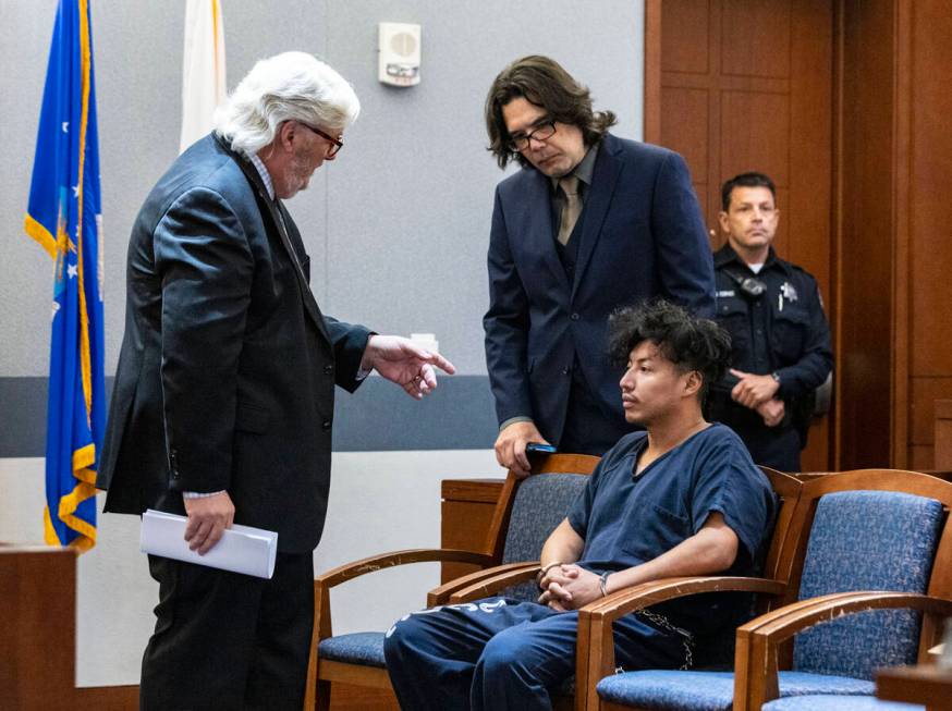 Yoni Barrios listens to Scott Coffee, left, and Jeff Maningo, public defenders, during a status ...