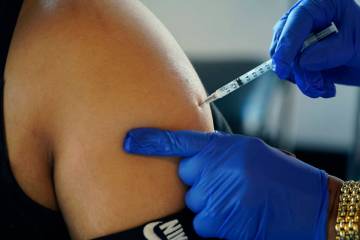A Jackson, Miss., resident receives a Pfizer booster shot from a nurse at a vaccination site Fe ...