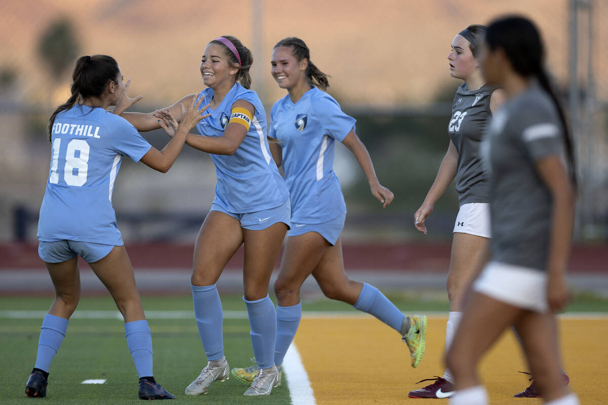 Foothill’s Brooklynn Phelps (18) congratulates her teammate Isabelle Simoneau, center, after ...