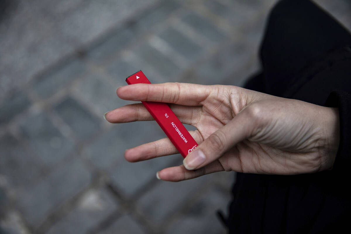 FILE - In this Jan. 31, 2020 photo a woman holds a flavored disposable vape device in New York. ...