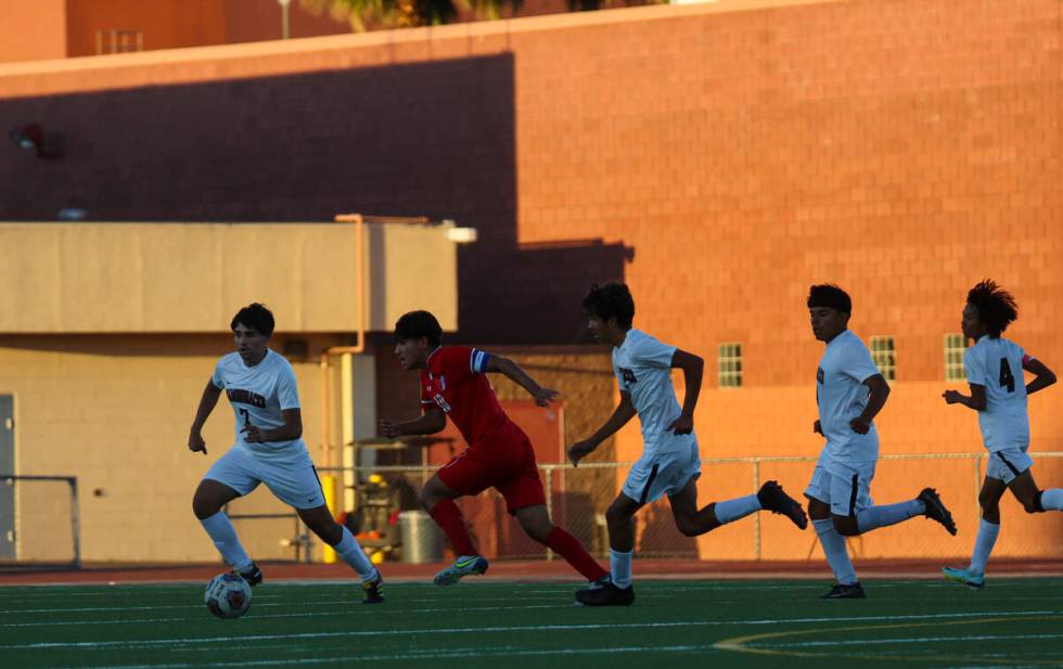 Western's Daniel Chavez (10) kicks the ball under pressure from Desert Oasis' Jose Vazquez-Estr ...