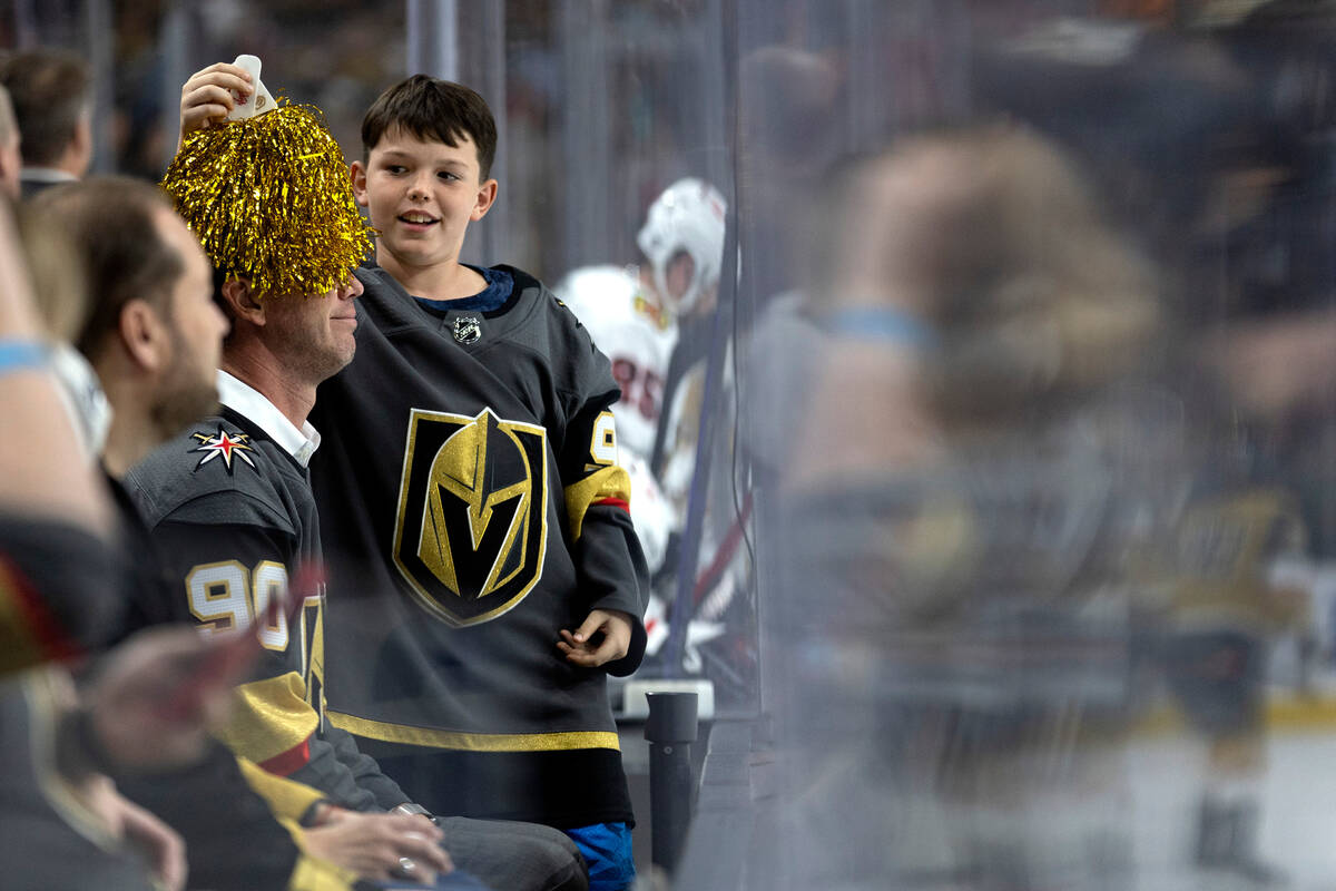 A young Golden Knights fan goofs off with a pom pom during the third period of an NHL hockey ga ...