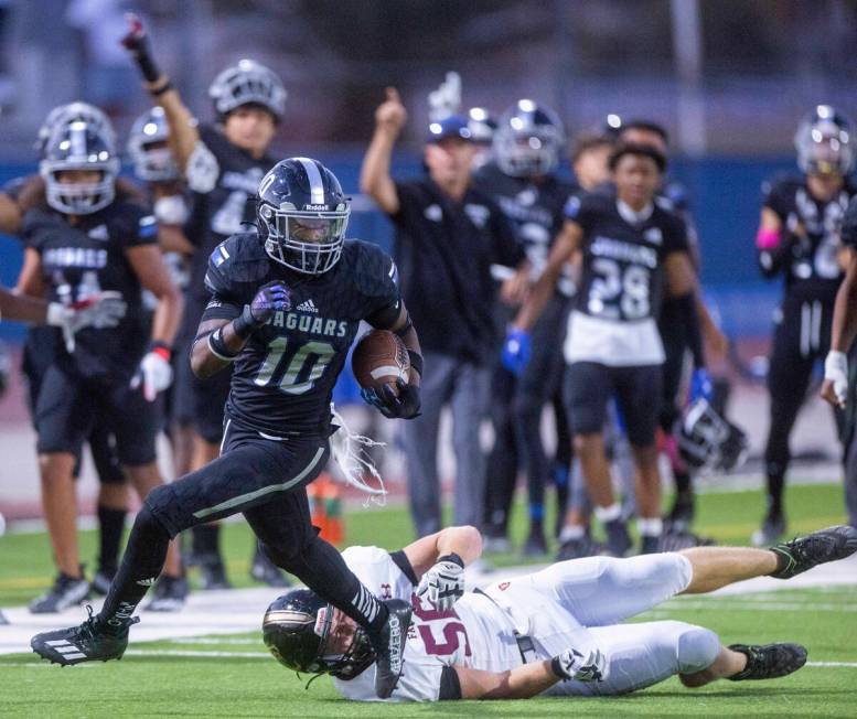 Desert Pines RB Gray Ryan (10) runs over Faith Lutheran's DL Gray Ryan (56) for a long run duri ...